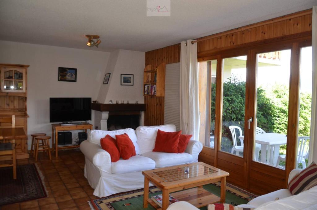a living room with a white couch with red pillows at Chalet Zou Derri 3 in Les Collons