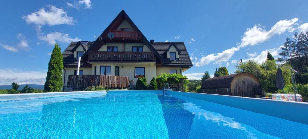 a house with a swimming pool in front of a house at Willa Maciejka in Trybsz