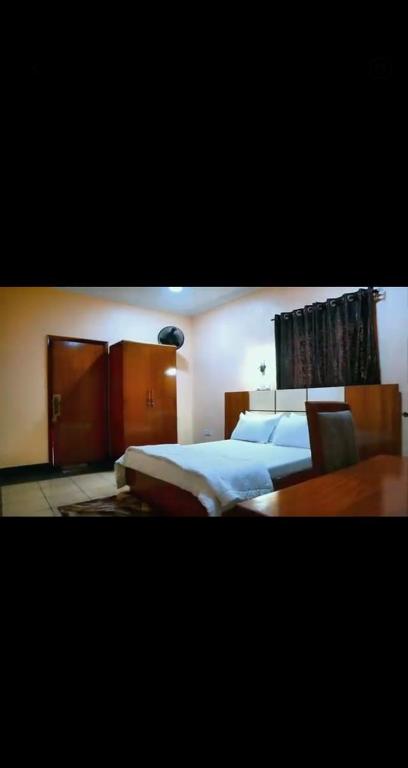 a bedroom with two beds and a table at NBTE Hotels in Kaduna