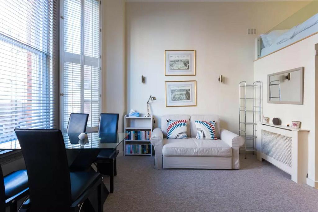 a living room with a white couch and a chair at Modern 1 bed Flat in Knightsbridge in London