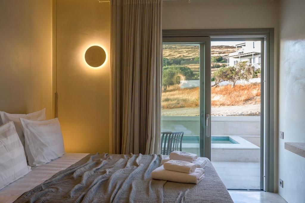 a bedroom with a bed and a window with a view at Lithos Luxury Suites in Tinos