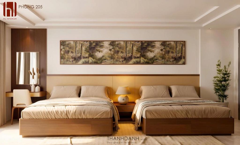 a bedroom with two beds and a painting on the wall at Thành Danh Hotel in Dong Hoi