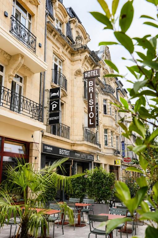 ein Gebäude mit Tischen und Stühlen davor in der Unterkunft Hotel Bristol in Luxemburg (Stadt)