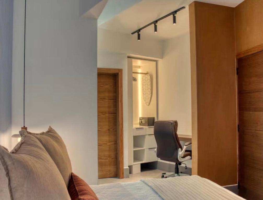 a bedroom with a bed and a desk and a chair at Torre Palmas Marcel in Ensanche Quisqueya