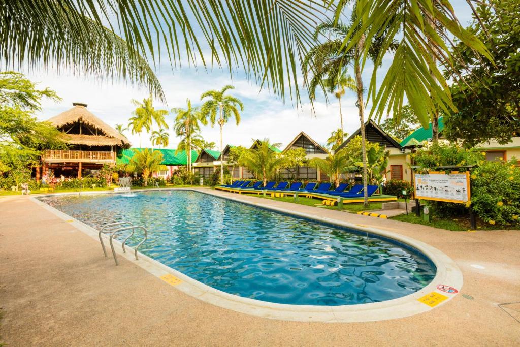 a large swimming pool in a resort with palm trees at Decameron Decalodge Ticuna in Leticia
