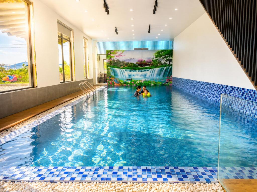 a swimming pool with two people in the water at Solwind Riverside in Danang