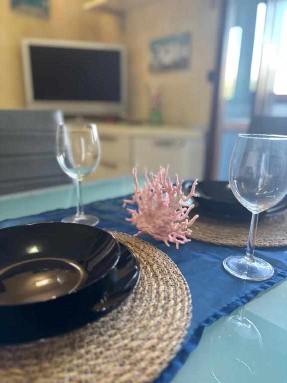 a table with two wine glasses and a plate and a napkin at Sea & spiagge a 200m Stella del Salento in Brindisi