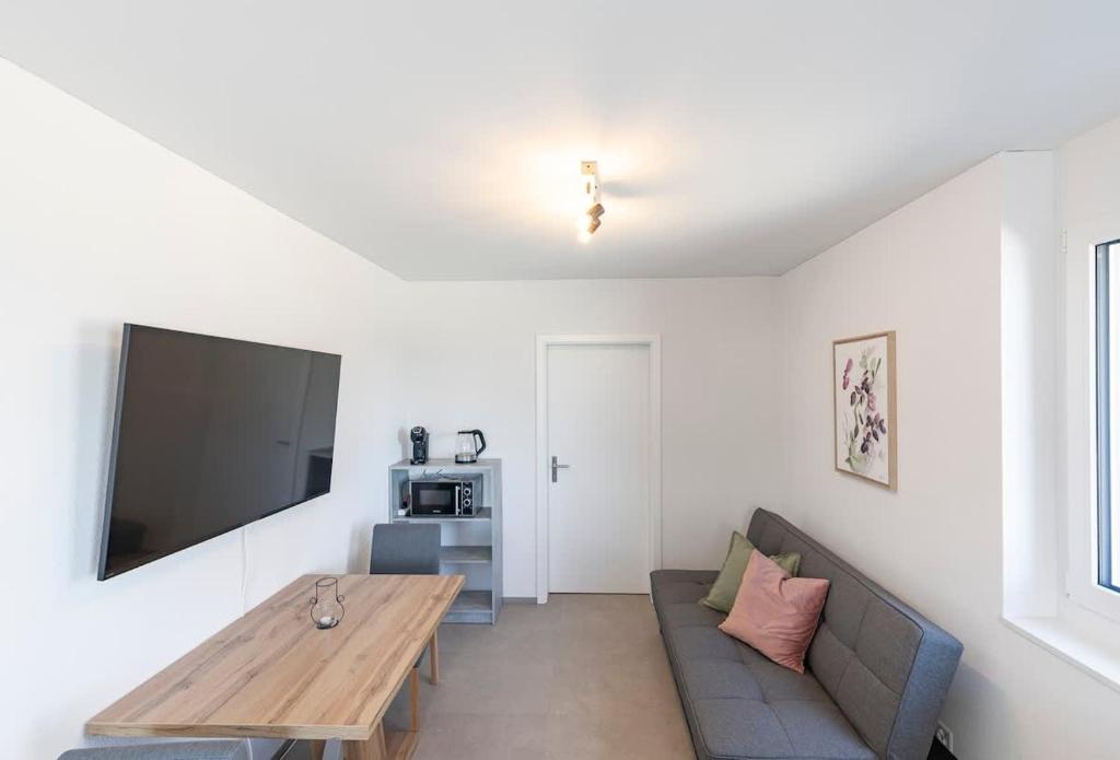 a living room with a couch and a table at Rothorn Studio - Aare Jungfrau AG in Spiez