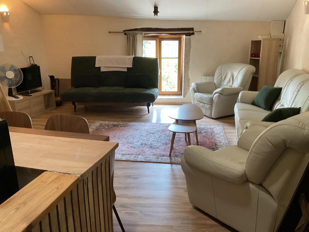 a living room with a couch and chairs and a table at Parenthèse clunysoise in Cluny
