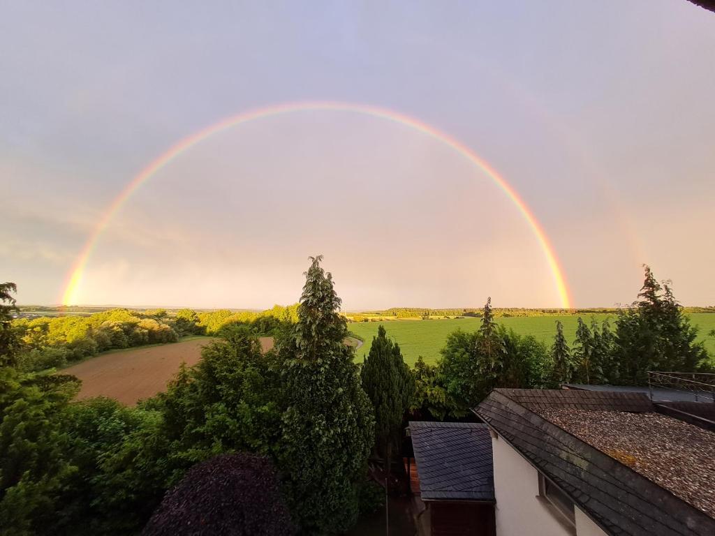 a rainbow in the sky over a field at Ferienwohnung Panoramaweg in Sohren