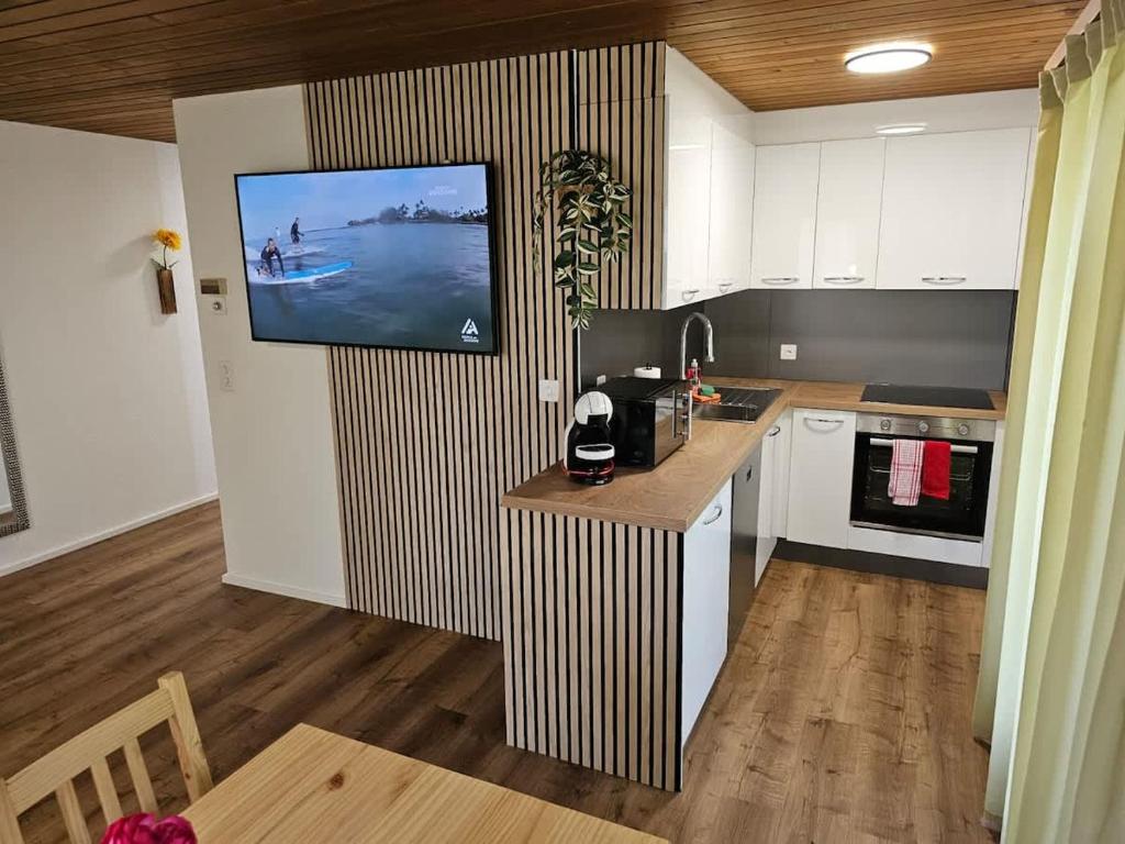 a kitchen with a tv hanging on a wall at Peak Apartment - Aare Jungfrau AG in Grindelwald