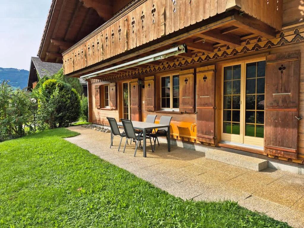 a patio with a table and chairs in front of a house at Apartment Chalet Condor - Aare Jungfrau AG in Grindelwald