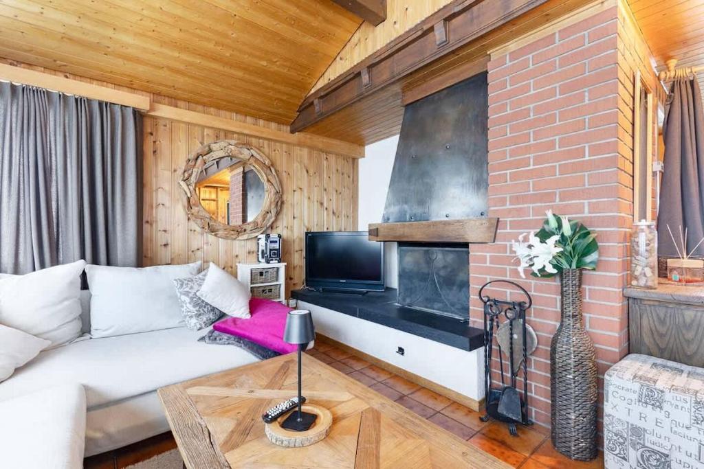 ein Wohnzimmer mit einem weißen Sofa und einer Backsteinwand in der Unterkunft Sara in Axalp