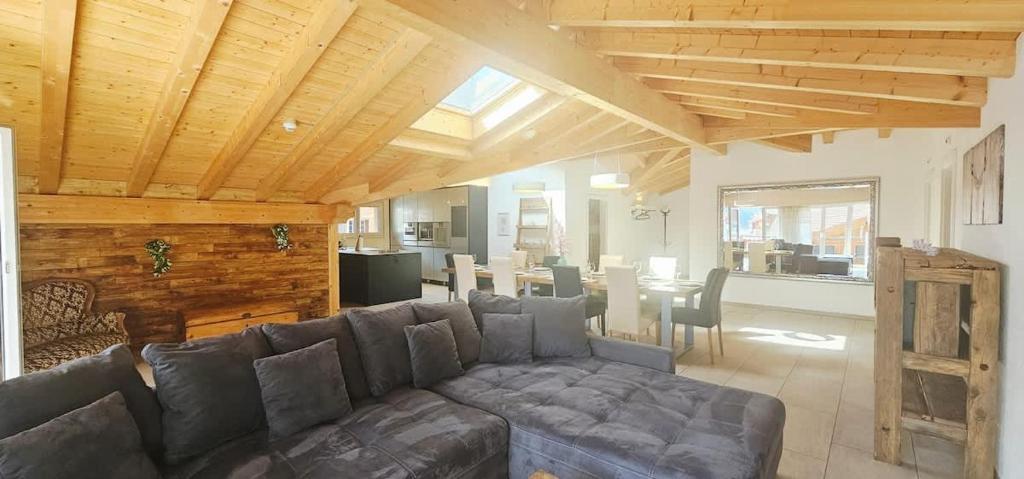 a living room with a couch and a dining room at Jungfrau Penthouse - Aare Jungfrau AG in Wilderswil