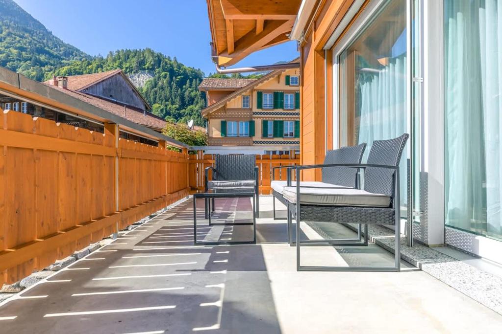 a balcony with two chairs and a table at Harder Apartment - Aare Jungfrau AG in Wilderswil