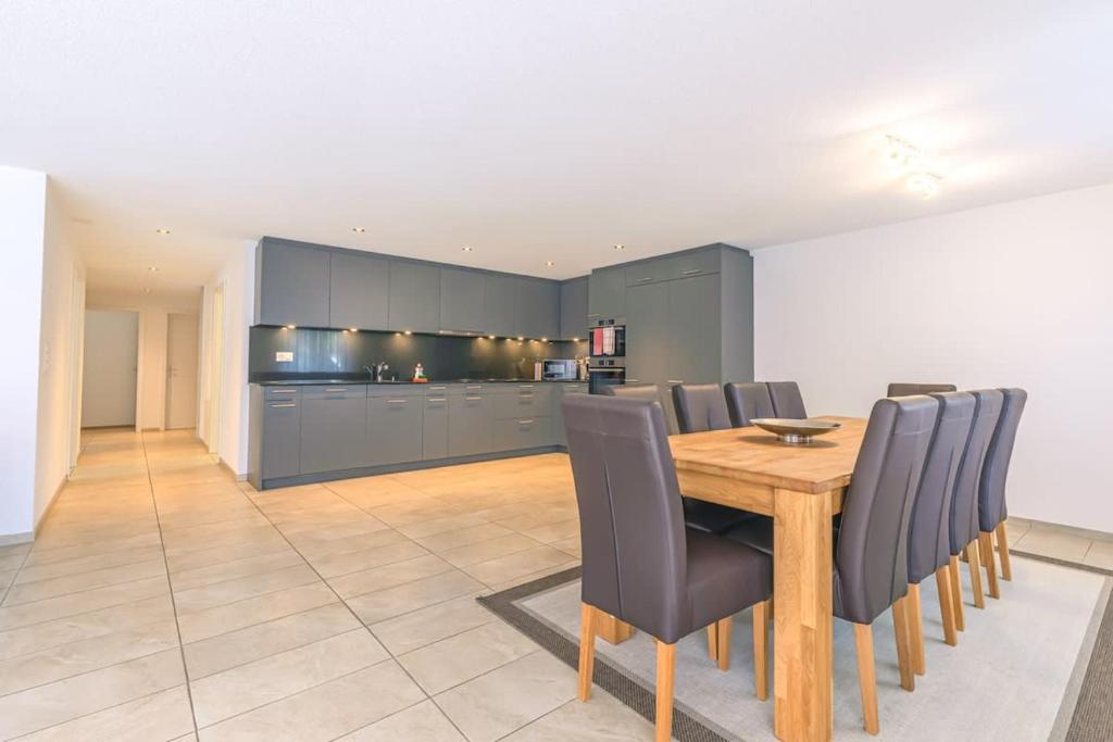 a kitchen and dining room with a wooden table and chairs at Schilthorn Apartment - Aare Jungfrau AG in Wilderswil