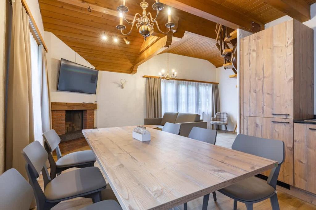 a dining room with a large wooden table and chairs at Apartment Eiger - Aare Jungfrau AG in Grindelwald