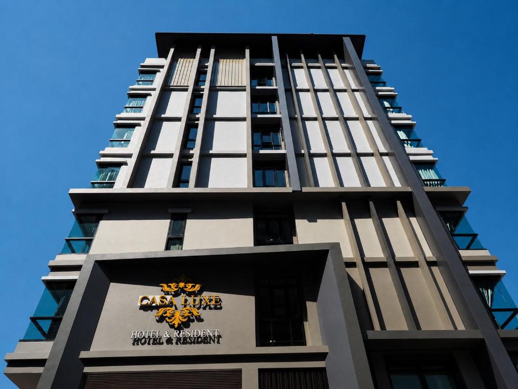 a tall black building with a sign on it at Casaluxe Hotel and Resident in Bangkok