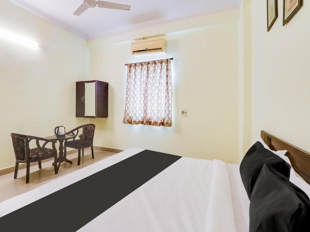 a bedroom with a bed and a dining table at Hotel O SS ELITE in Karīmnagar
