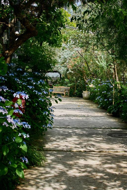 a path in a park with a bench and flowers at BIRD HOTEL in Kamakura