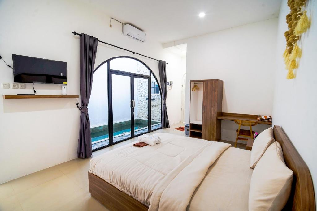 a bedroom with a large bed with a large window at Timeless Sevilla Luxe in Ngemplak