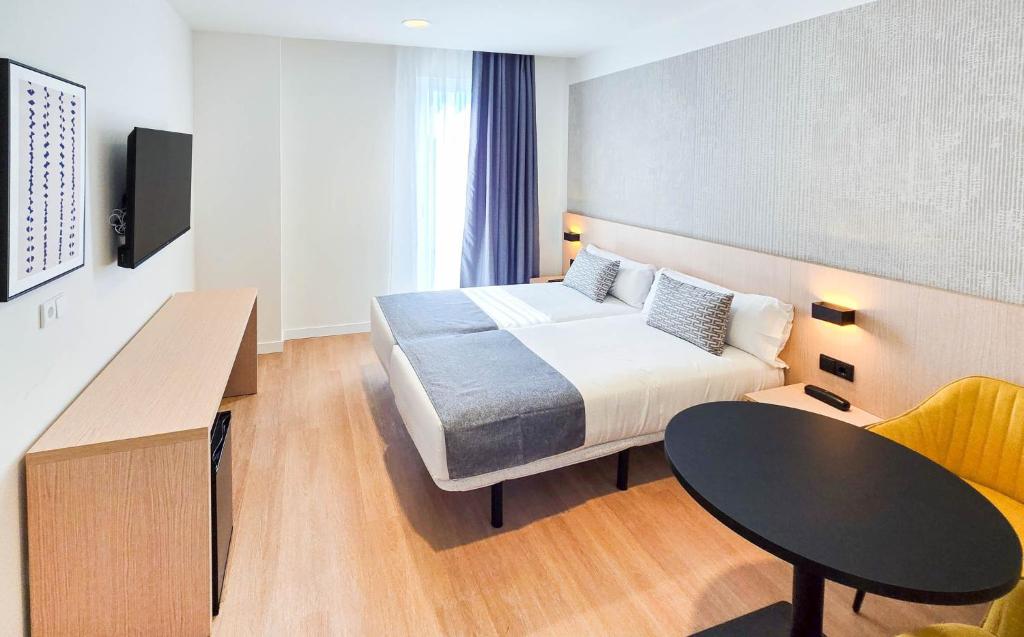 a hotel room with a bed and a table at DWO San Sebastián in San Sebastián