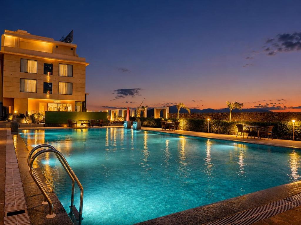 a swimming pool in front of a building at night at Sterling Pushkar in Pushkar