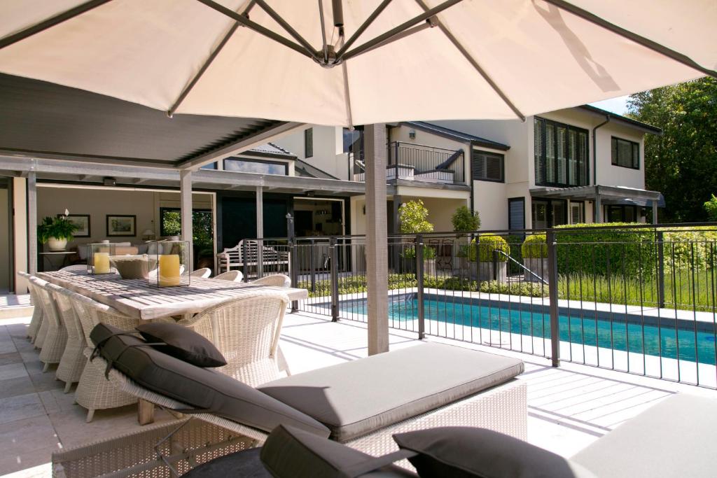 a patio with a table and chairs and an umbrella at The Point Villas in Taupo