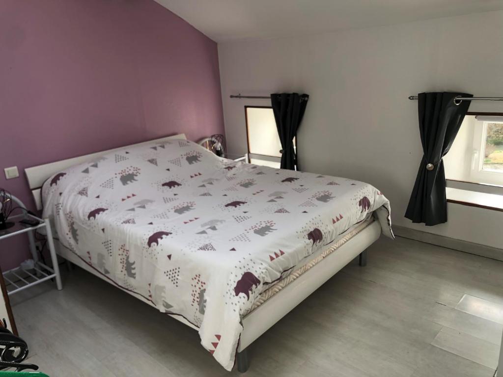 a bedroom with a bed with a white comforter at Meublé lilas in Réaumur