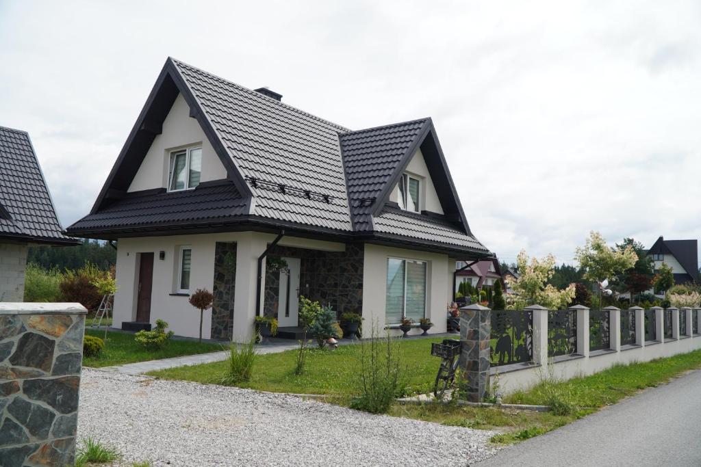 a house with a black roof at Szczyt i Sosna in Krauszów
