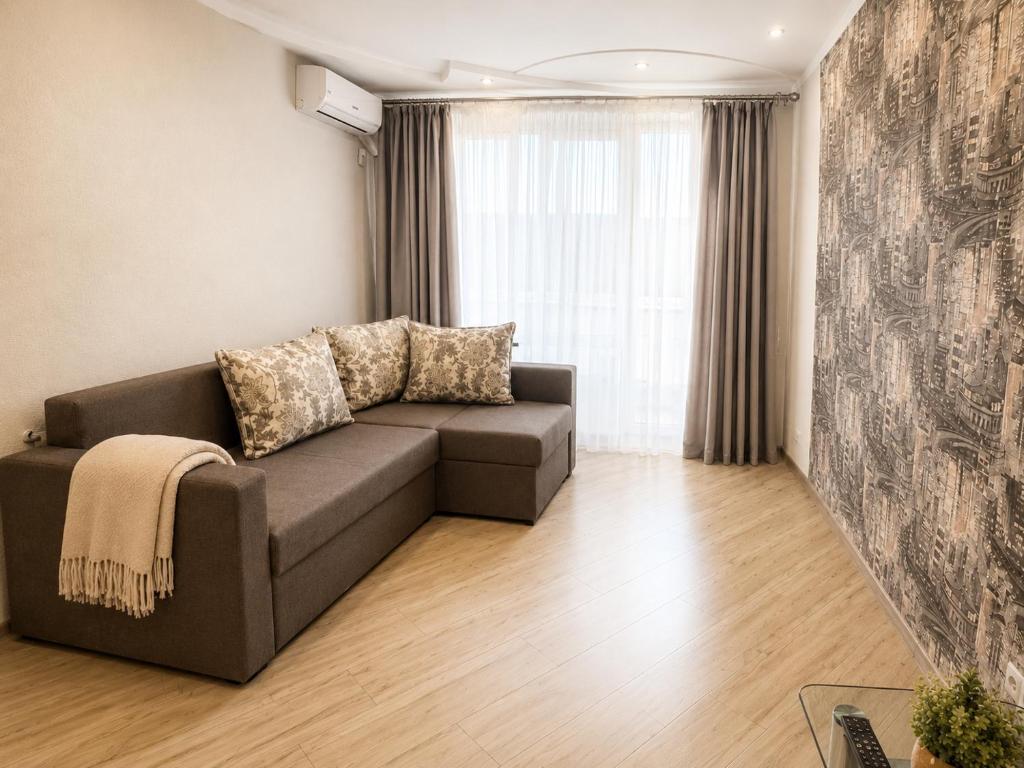 a living room with a couch and a window at Luxury 3 Rooms Apartments in Center by Green House in Poltava