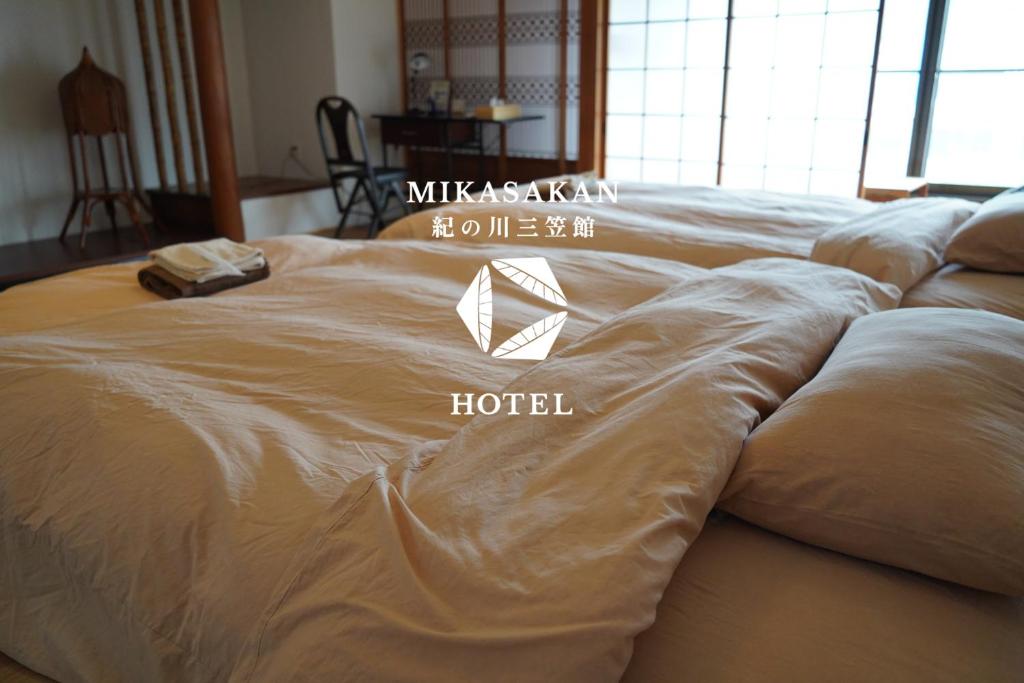 a bed with a hotel sign on top of it at 三笠館Mikasakan 本館 in Kinokawa
