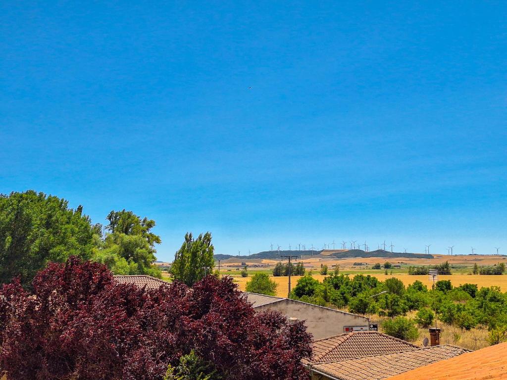 a view of a farm with trees and a blue sky at Hotel-Albergue Puente Fitero in Itero de la Vega