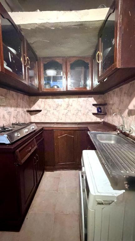 a kitchen with wooden cabinets and a sink at lala salama in Zanzibar City
