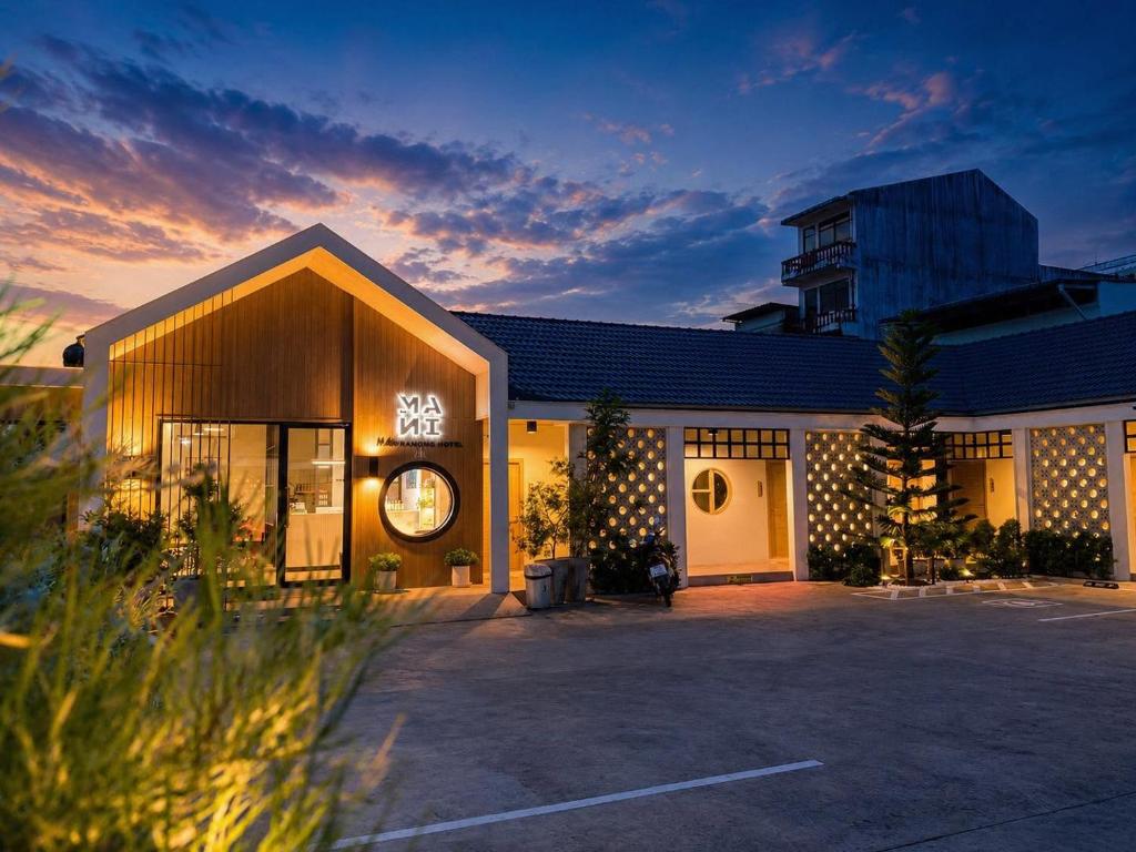 a building with a parking lot in front of it at Mani Ranong Hotel in Ranong