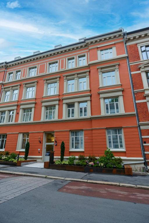 an orange building with white windows on a street at MAYA Apartments - Vika in Oslo