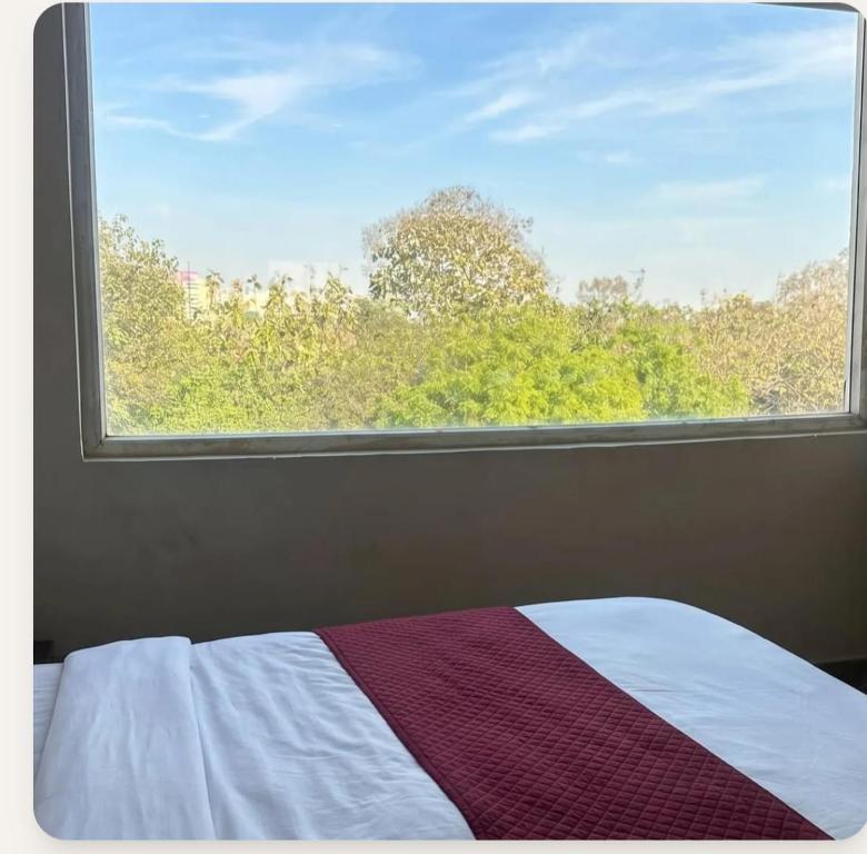 a bedroom with a window with a bed and a blanket at YU Turn Celebrations in Greater Noida