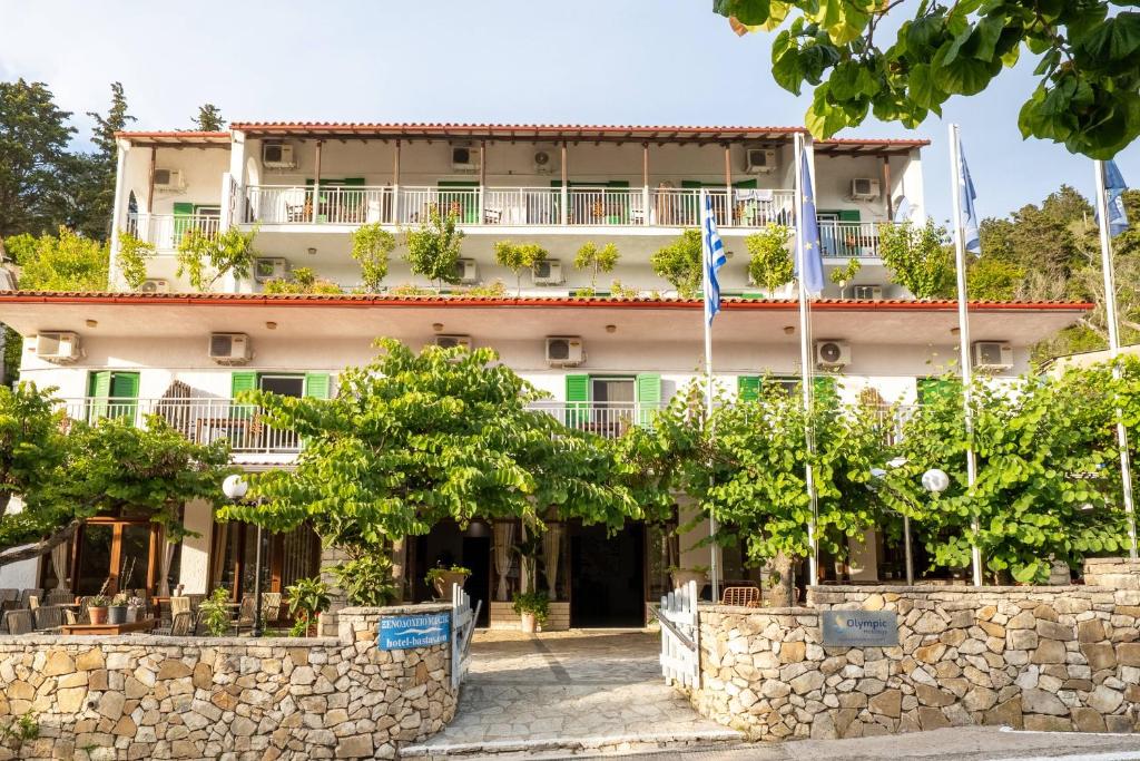 ein großes Gebäude mit Bäumen davor in der Unterkunft Bastas Hotel in Lákka