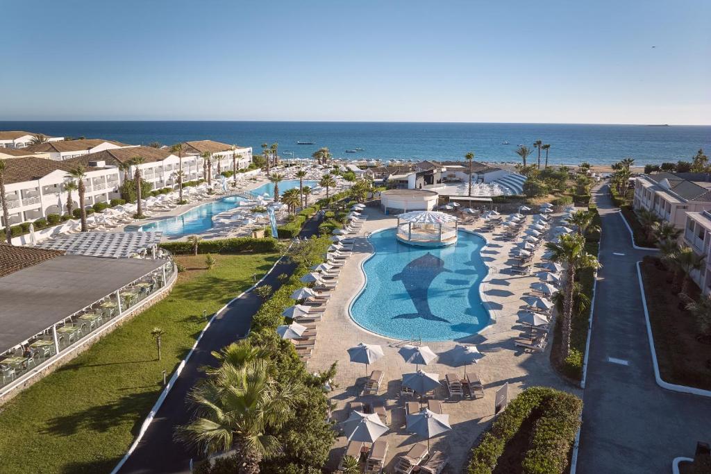 an aerial view of a resort with a pool and the ocean at Sandy Beach Resort by Rizos Resorts in Agios Georgios