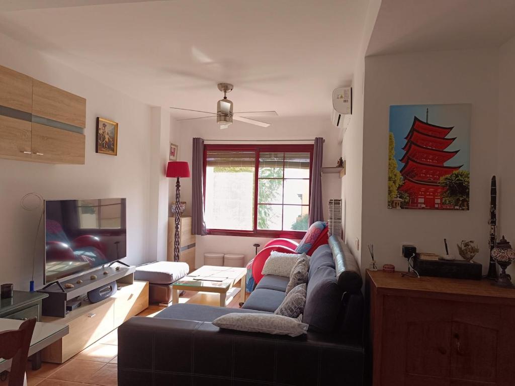 a living room with a couch and a tv at Casa Cármenes del Mar in Almuñécar