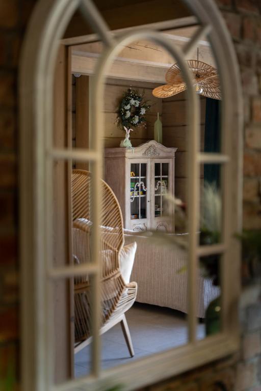a reflection of a room with a chair in a window at Przytulisko Bieszczady in Smerek