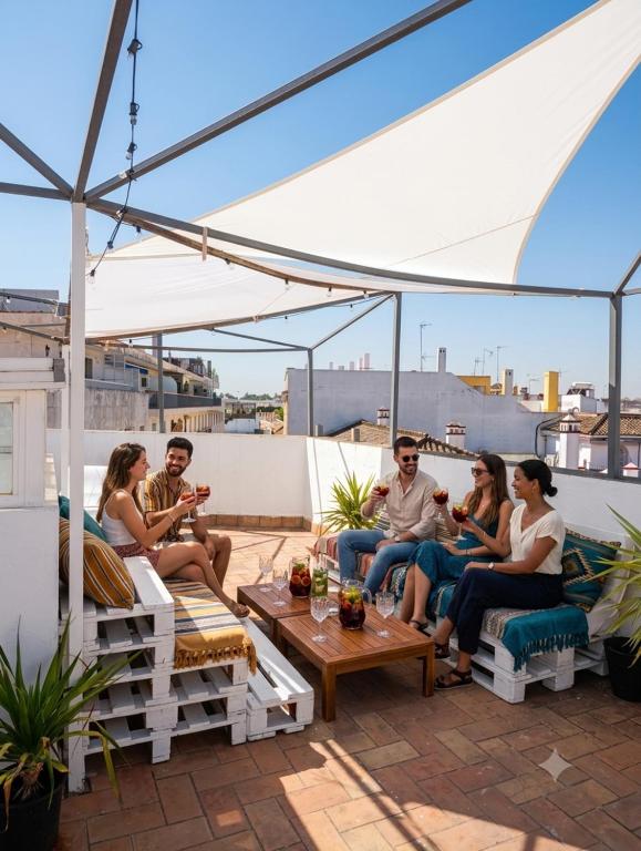 a group of people sitting on a roof at Black Swan Hostel Sevilla in Seville