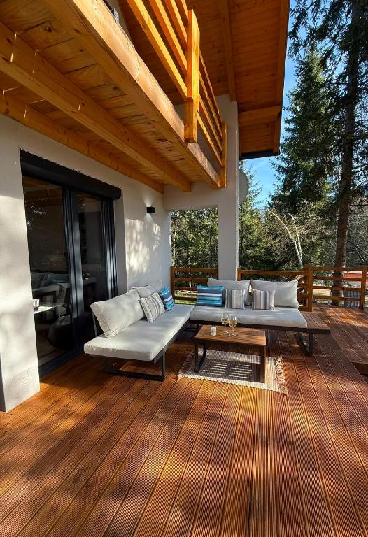a patio with couches and a table on a deck at Hidden pines in Gornji Čevljanovići