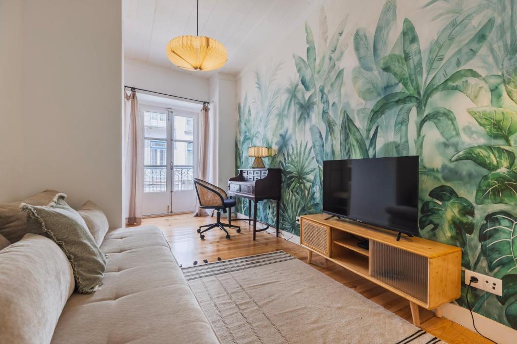 a living room with a tv and a mural of plants at A cozy hideout in Lisbon
