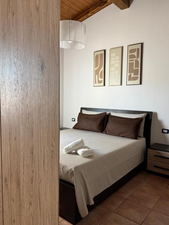 a bedroom with a bed with a wooden wall at Mespilia - Tra Mare e Città in Latina