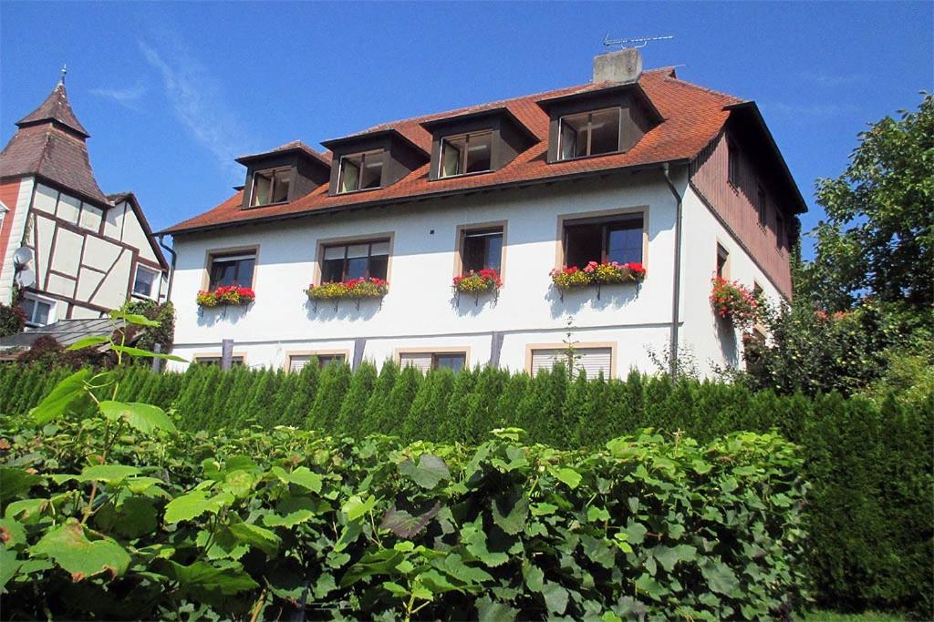 a white building with windows and flowers on it at Gästehaus Ainser in Hagnau