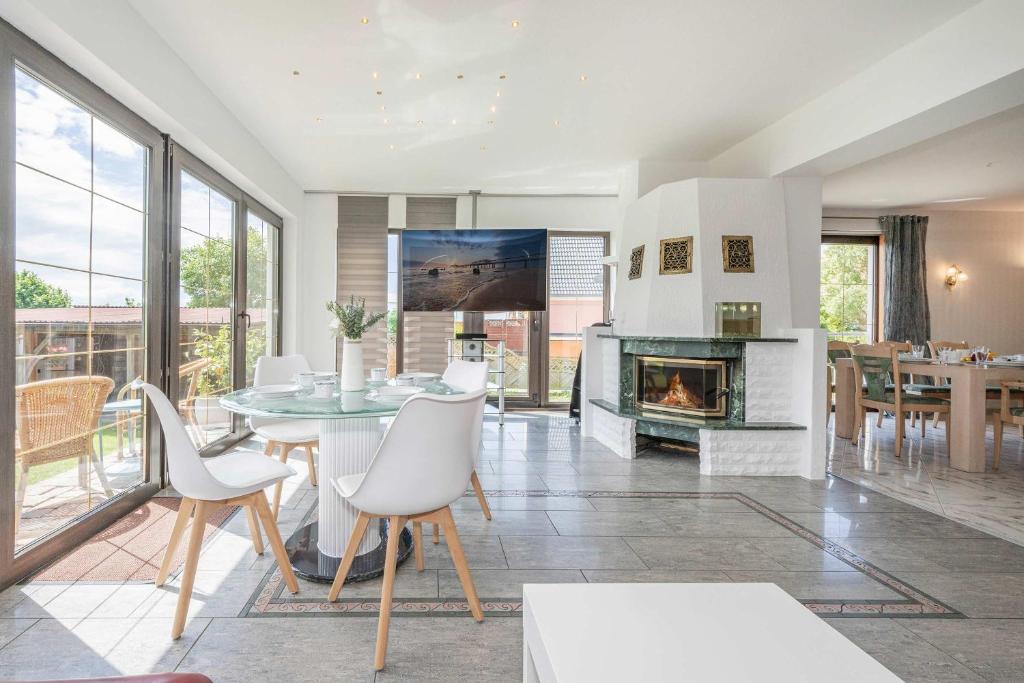 a living room with a fireplace and a table and chairs at Ferienhaus Sonnendeck in Ueckeritz