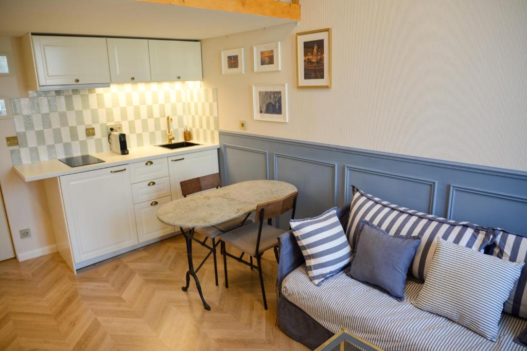 a living room with a couch and a table and a kitchen at The Blue Cottage in Nice