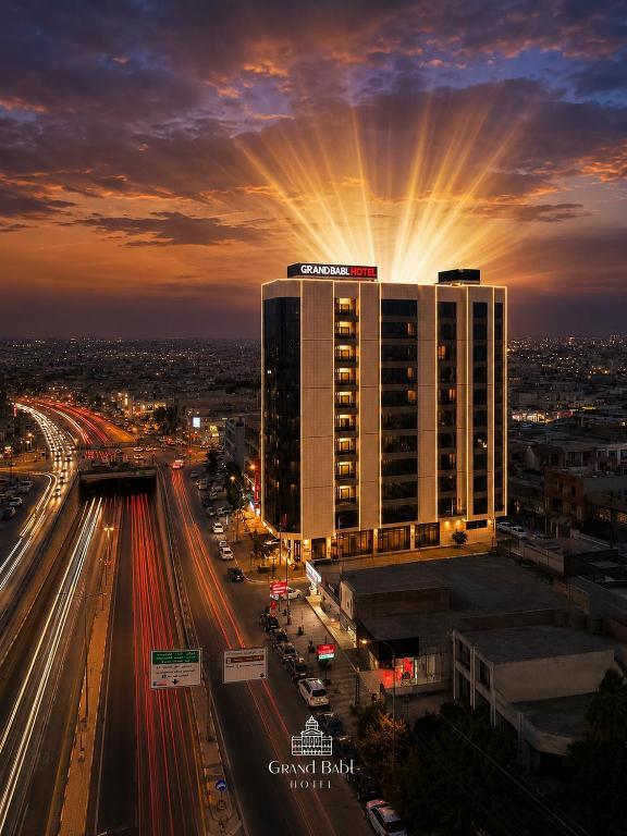 a building with the sun shining on top of it at Grand Babl in Erbil