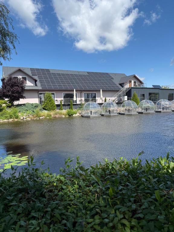 a house with a lot of solar panels on the water at Hotel Nenufar Premium in Kościan